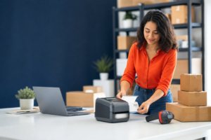 Small business owner at an automated packing station with printer and scanner, wide workspace for headline